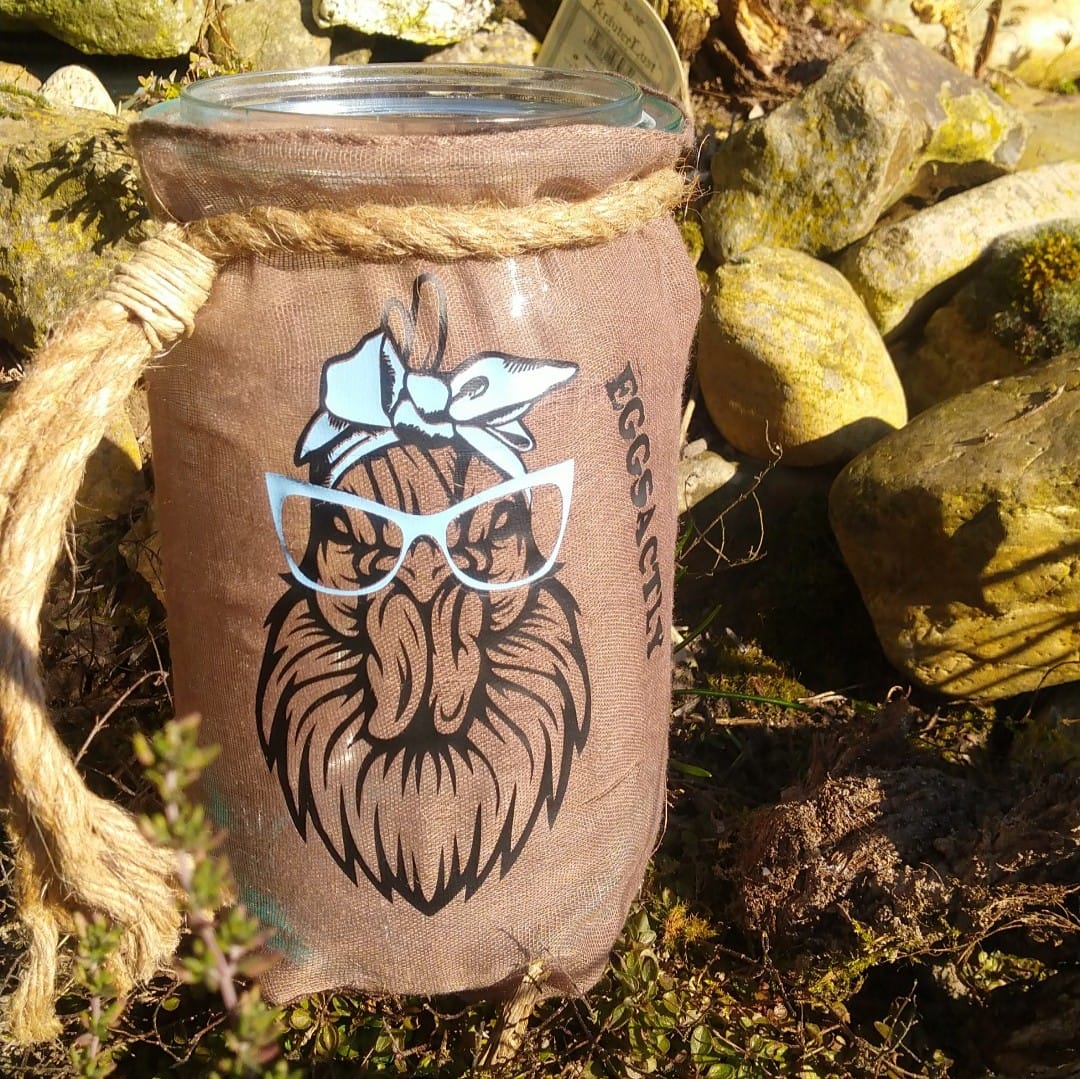 Kreatives Glasgefäß, das mit der "EGGSACTLY" Plotterdatei von easy-sticks verziert ist, zeigt eine Hühnergrafik mit Brille, ideal für DIY-Projekte.