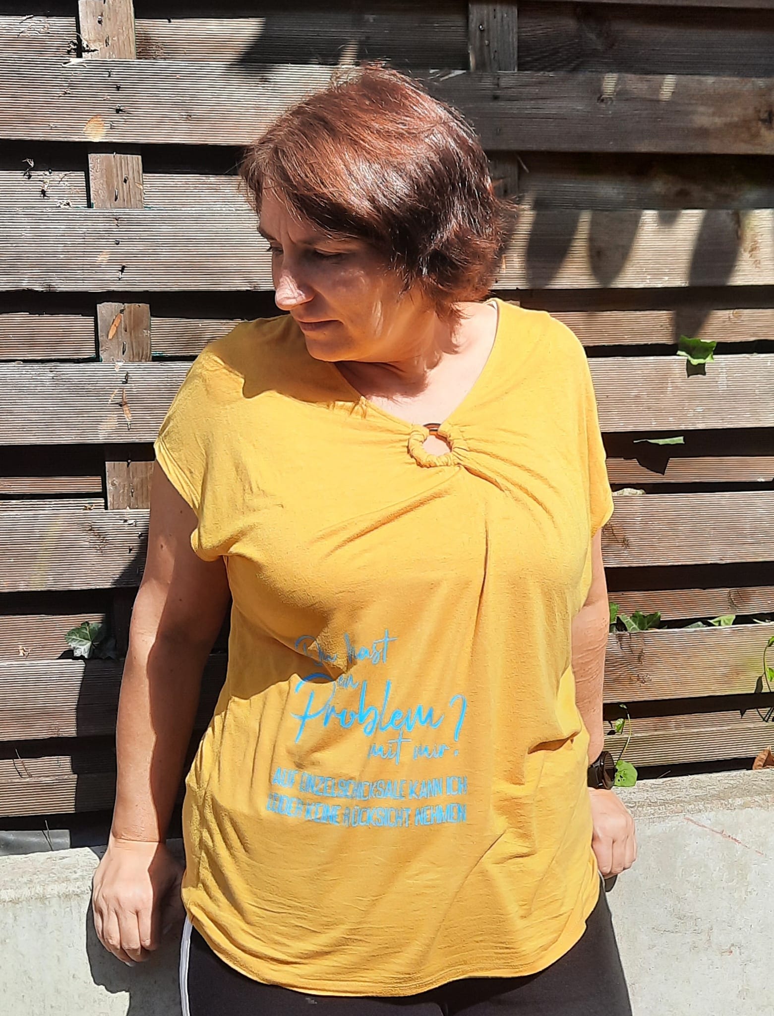 Frau in gelbem Shirt mit dem Spruch: "Du hast ein Problem mit mir? Auf Einzelschicksale kann ich leider keine Rücksicht nehmen" von easy-sticks, modisches Statement für jeden Anlass.