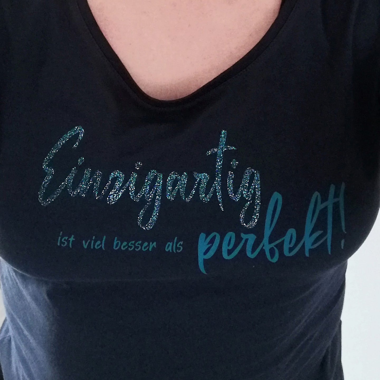 Detailaufnahme eines T-Shirts mit dem glitzernden Spruch "Einzigartig ist viel besser als perfekt!" von easy-sticks, perfekt für kreative DIY-Projekte.