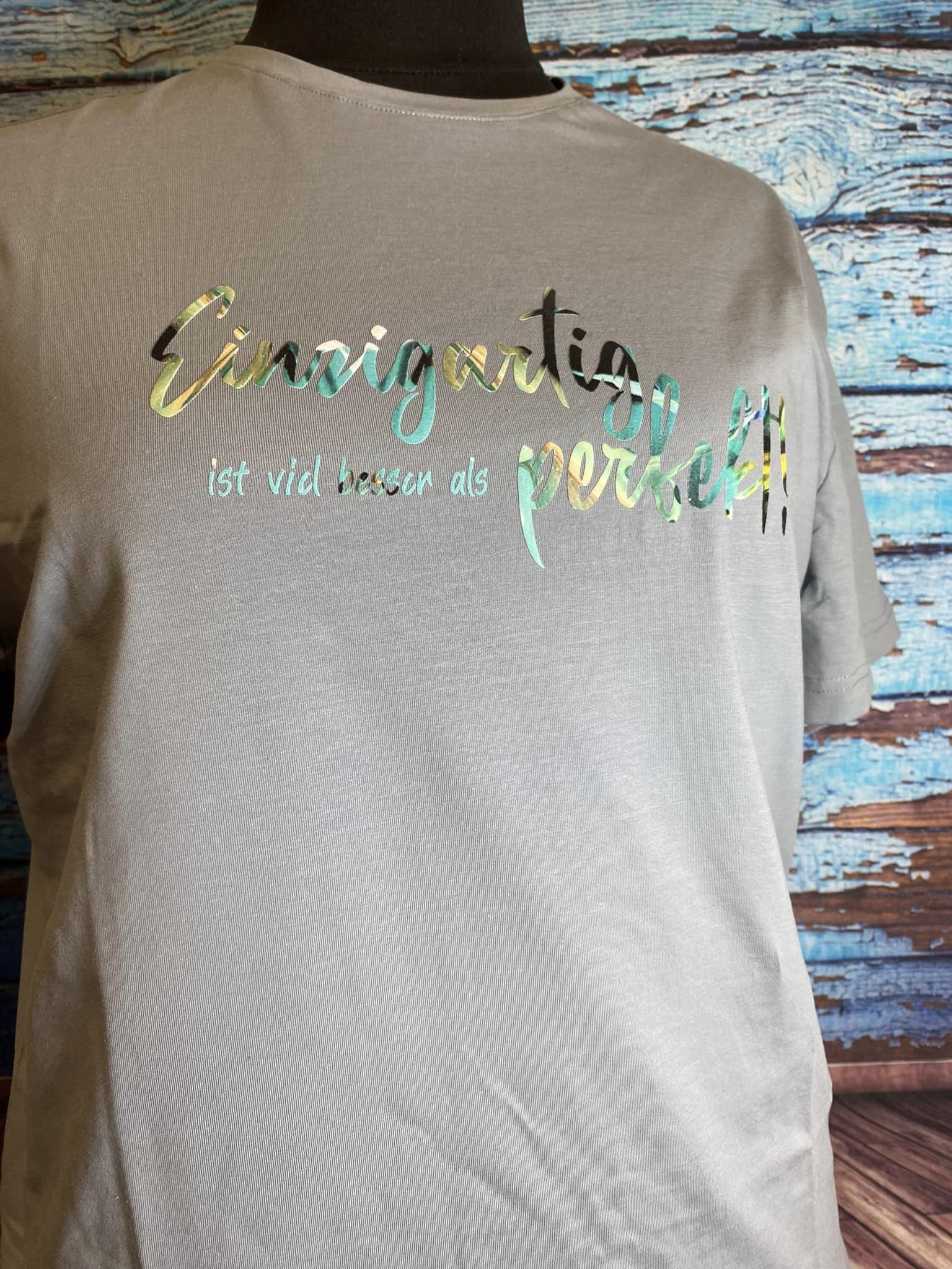 Ein graues T-Shirt mit dem Aufdruck "Einzigartig ist viel besser als perfekt!" von easy-sticks, geeignet für individuelle Mode.