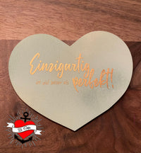 Eine herzförmige Holzplatte mit dem Spruch "Einzigartig ist viel besser als perfekt!" von easy-sticks, wunderschön für persönliche Geschenke.