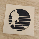 Eishockey Plotterdatei von easy-sticks - Holzplatte mit lasergraviertem Eishockeyspieler vor einem runden Hintergrund und horizontalen Linien, ideal für kreative DIY-Projekte.