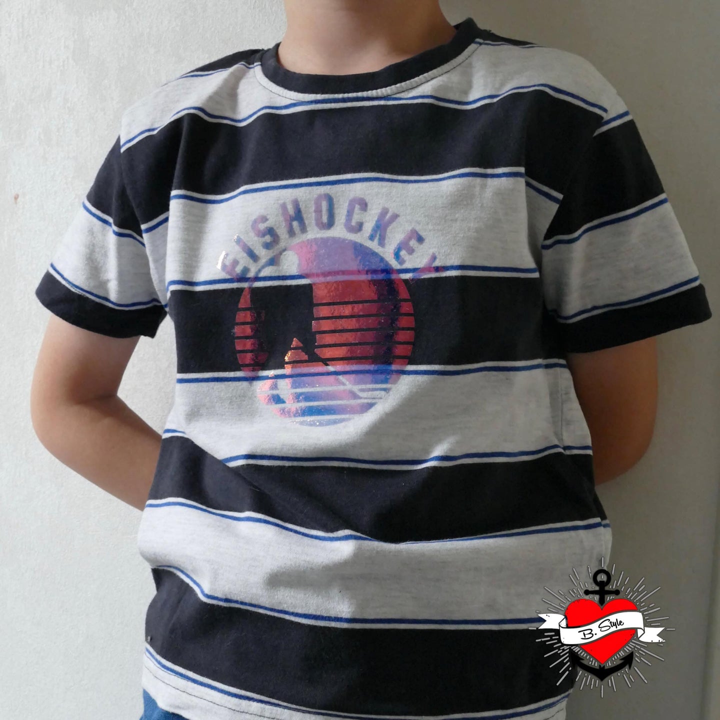 Kind in gestreiftem T-Shirt mit Eishockey Plotterdatei von easy-sticks - das Shirt zeigt ein kreatives Eishockey-Design in lebhaften Farben, perfekt für passionierte Eishockeyfans.