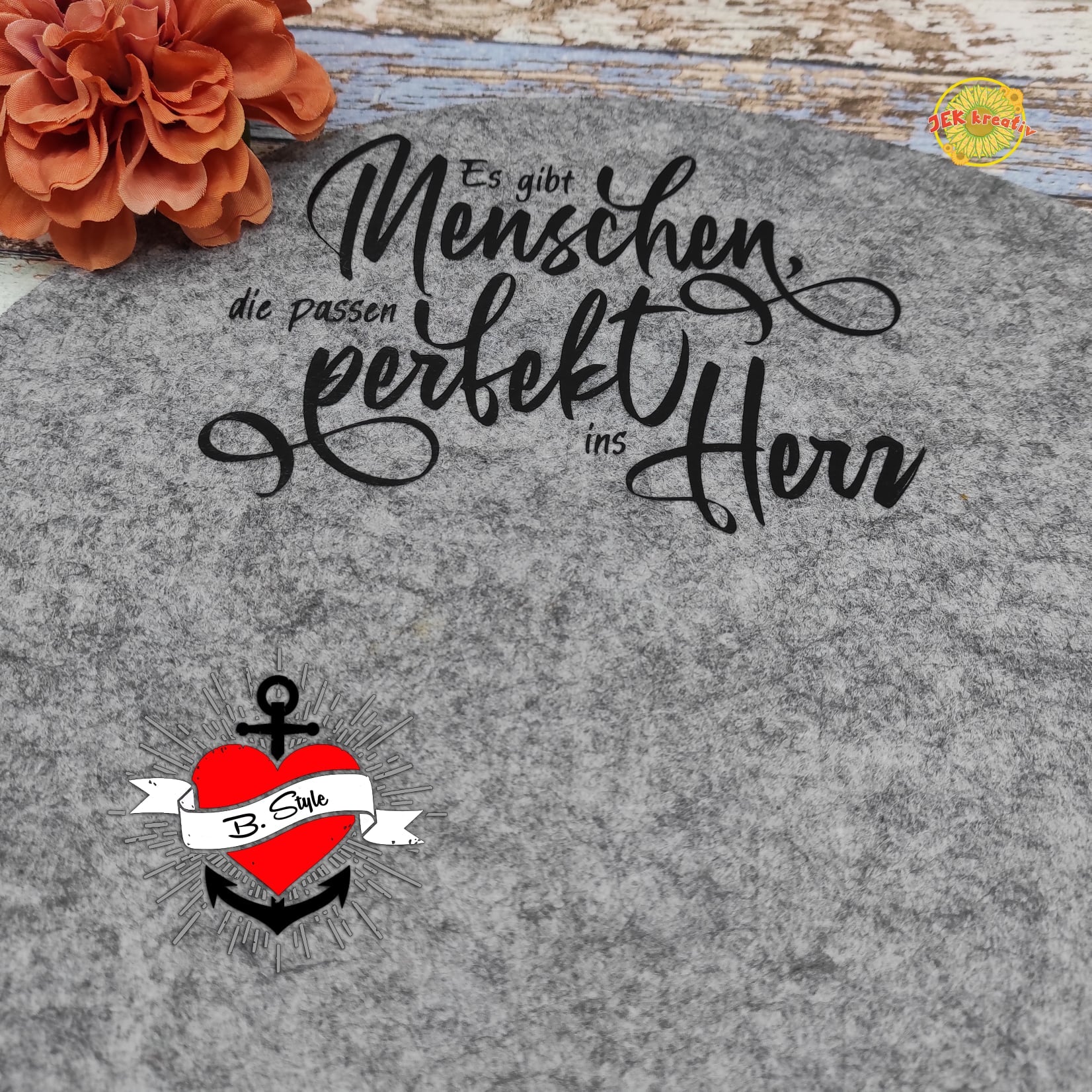 Verleihe Filzprojekten eine persönliche Note mit der Plotterdatei "Es gibt Menschen die passen perfekt ins Herz" von easy-sticks. Abgebildet ist die inspirierende Schrift auf einem Filzuntergrund.