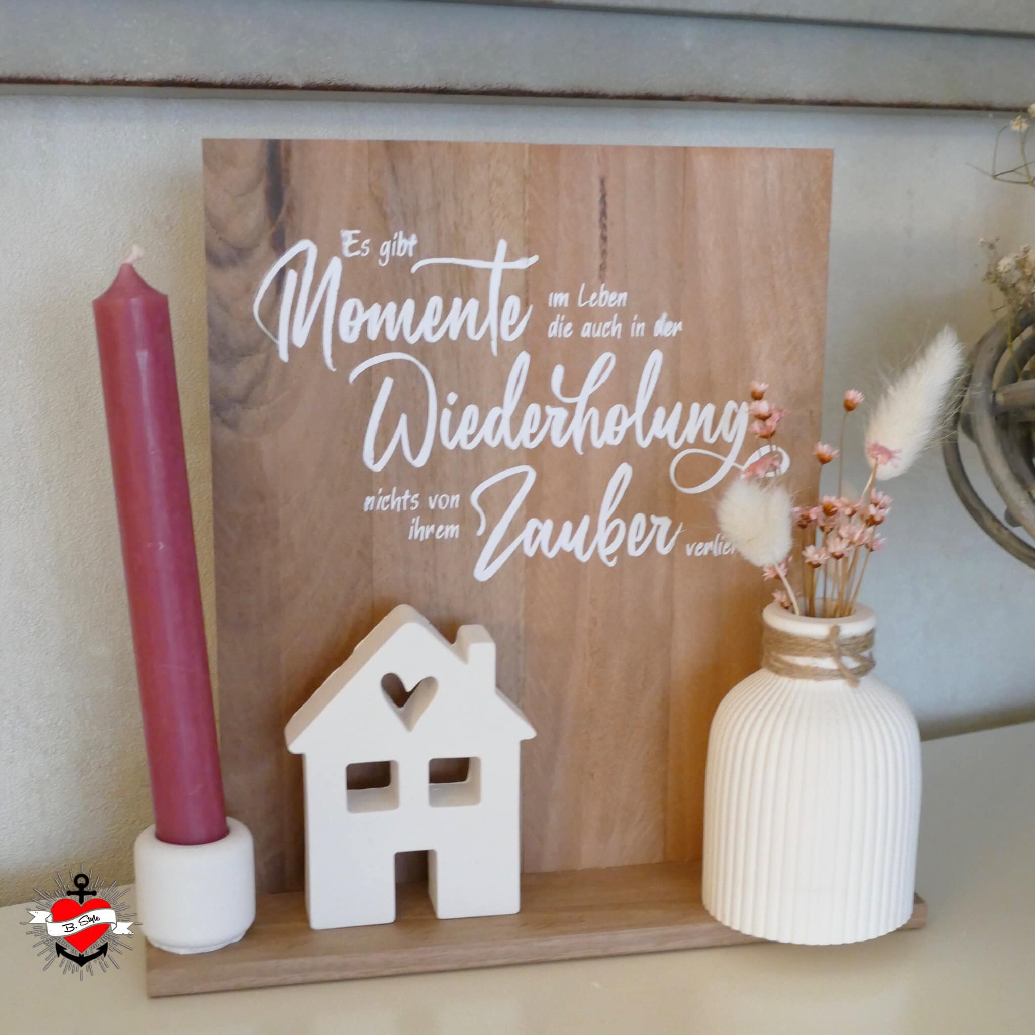 Wanddekoration mit dem Zitat "Es gibt Momente im Leben die auch in der Wiederholung nichts von ihrem Zauber verlieren" von easy-sticks, stilvoll auf Holz präsentiert.