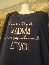 Ein dunkelblaues Shirt präsentiert den Spruch "Es schreibt sich Karma Aber ausgesprochen wird es Ätsch" von easy-sticks, eine tolle Auswahl für entspannte Outfits.