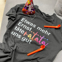 Gemütliches T-Shirt mit dem Spruch "Etwas mehr Ernst..täteratata uns gut" von easy-sticks, verfremdet durch die bunte Grafik, basierend auf der Plotterdatei.