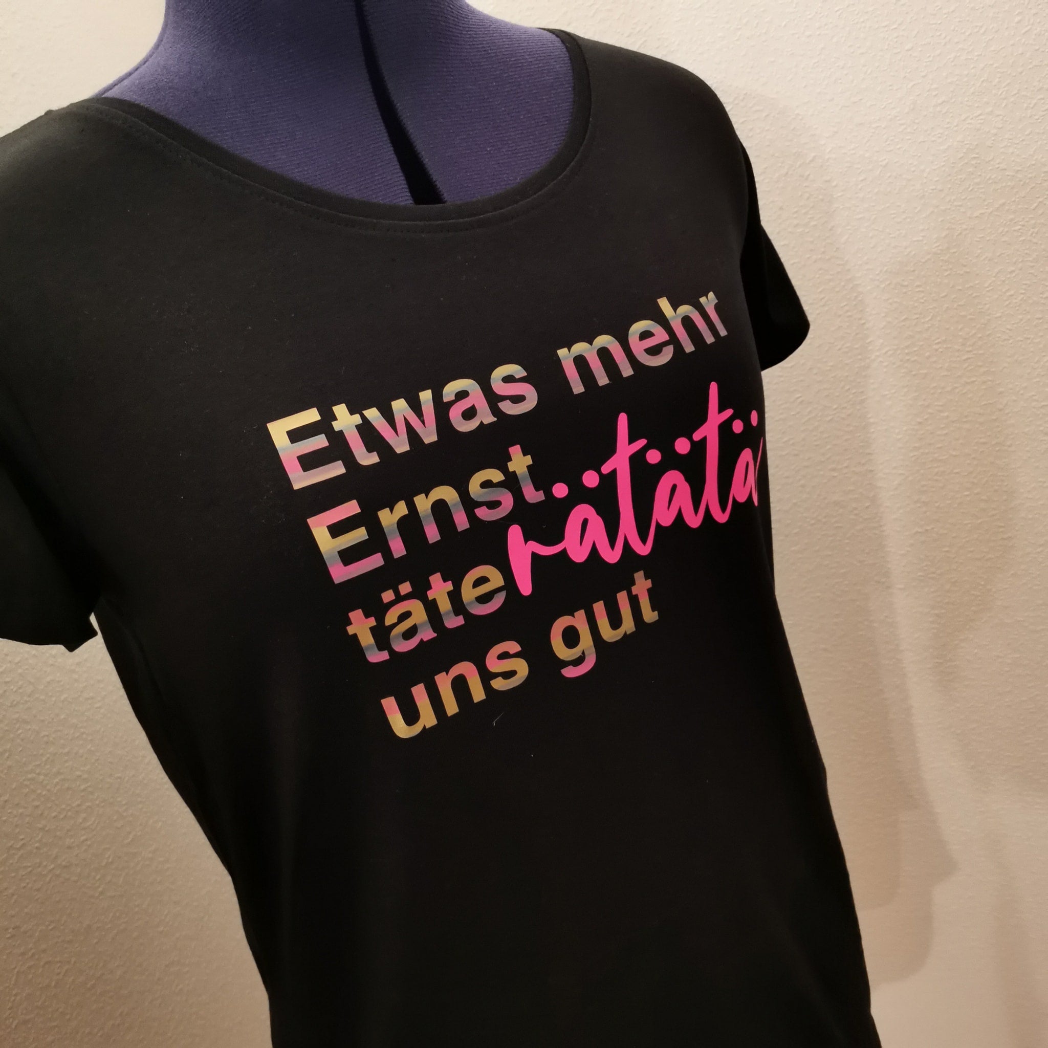 Schwarzes T-Shirt mit dem Aufdruck "Etwas mehr Ernst..täteratata uns gut" von easy-sticks, inspiriert von der Plotterdatei, perfekt für kreative Projekte.
