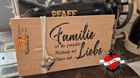 Ein weiteres Holzschild mit der Botschaft "Familie ist die perfekte Mischung aus Liebe und Chaos" von easy-sticks, als dekoratives Element auf einem Tisch platziert.