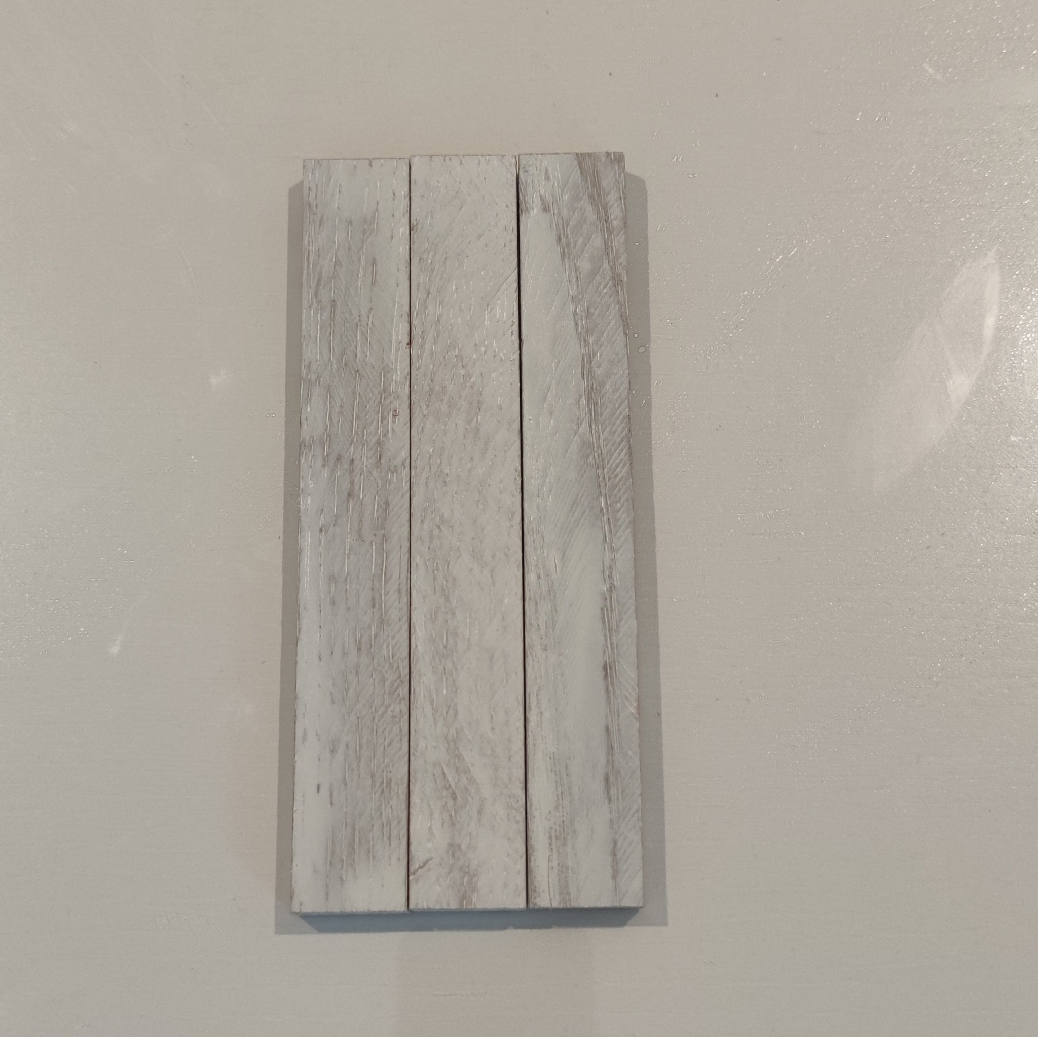 Eine Holzprobe in Weiß, lackiert mit Easy-Sticks Color Holzlasur - Weiß Deckend, präsentiert die hochwertige Farbe ideal für kreative Innenprojekte.