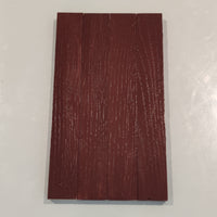 Detailaufnahme einer mit Easy-Sticks Color Holzfarbe Schweden Rot gestrichenen Holzfläche, die ihre reichhaltige Farbe und Struktur zeigt.