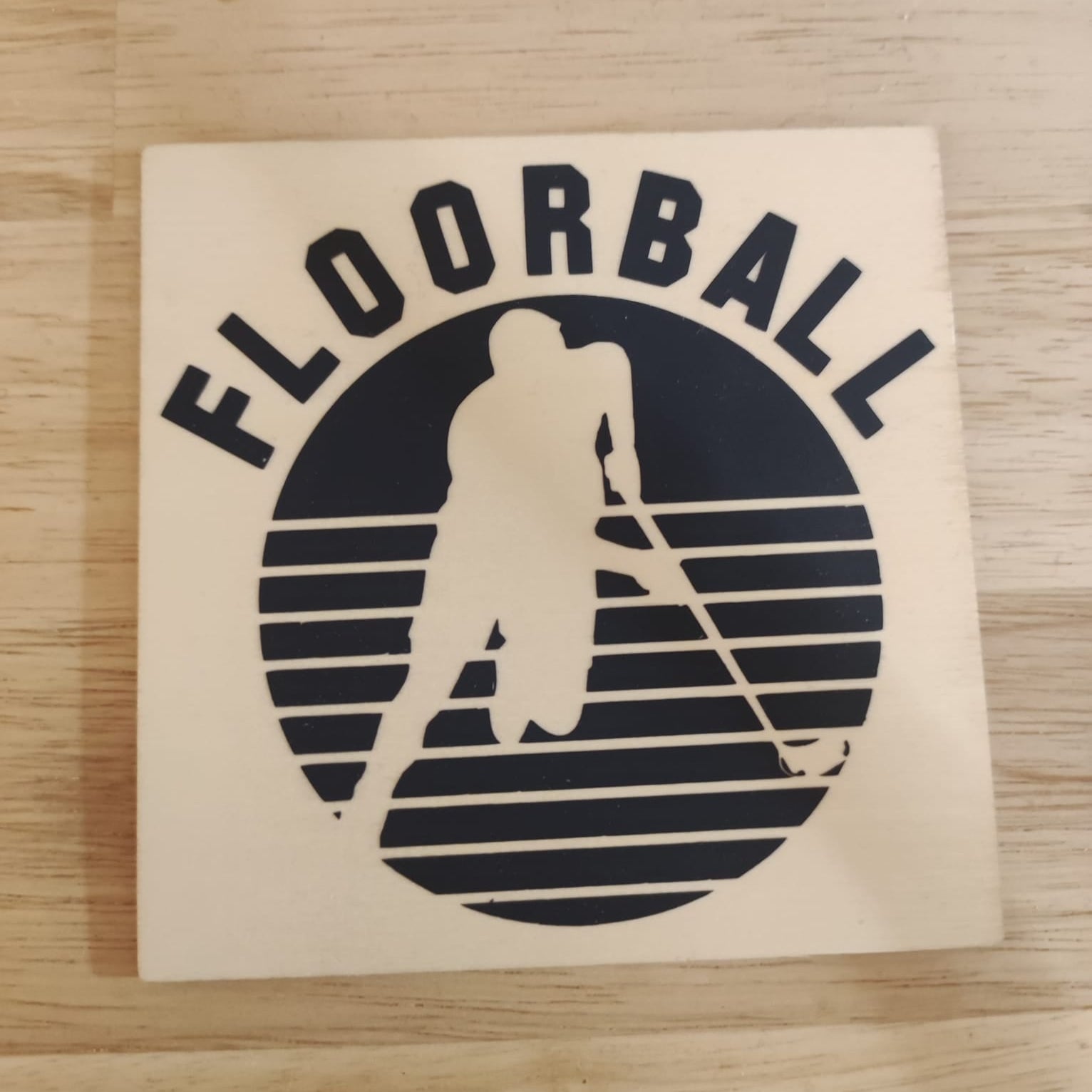 Holzplatte mit Floorball Design und Spieler-Silhouette, geliefert von easy-sticks, ideal für Bastel- und DIY-Projekte mit der Floorball Plotterdatei.