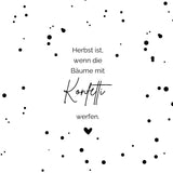 Schlichte Eleganz der Herbst Konfetti Laterne und Lichtbox von easy-sticks. Detailaufnahme eines minimalistischen Designs mit einem poetischen Spruch auf weißem Hintergrund, geschmückt mit schwarzen Farbspritzern. Herbst, wenn die Bäume mit Konfetti werfen.