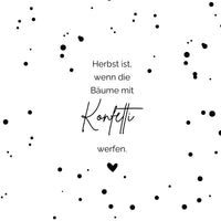 Schlichte Eleganz der Herbst Konfetti Laterne und Lichtbox von easy-sticks. Detailaufnahme eines minimalistischen Designs mit einem poetischen Spruch auf weißem Hintergrund, geschmückt mit schwarzen Farbspritzern. Herbst, wenn die Bäume mit Konfetti werfen.