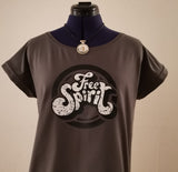Modisches graues T-Shirt mit dem 'Free Spirit' Logo an einer Schneiderpuppe, designt von easy-sticks, perfekt für kreative Outfits.