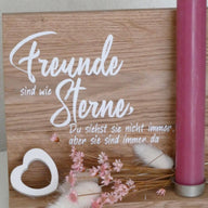 Hochwertige Holzplatte mit dem Schriftzug "Freunde sind wie Sterne, Du siehst sie nicht immer, aber sie sind immer da". Dekorative Kerze und florale Akzente bilden einen stilvollen Tischschmuck. Perfekt für kreative DIY-Projekte mit der Plotterdatei von easy-sticks.