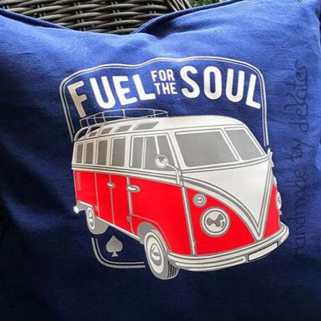 Stylisches Kissen mit dem Aufdruck 'Fuel for the soul', präsentiert von easy-sticks, auf einem w wicker Sessel im Garten.