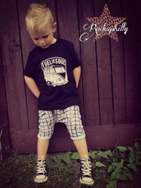 Kindermode im Streetstyle mit dem T-Shirt "Fuel for the soul" von easy-sticks, zeigt einen Jungen mit einem coolen schwarzen Shirt und karierter Hose.