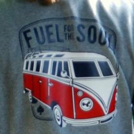 Stylisches Sweatshirt mit dem Print "Fuel for the soul" von easy-sticks, präsentiert auf einer Person im Garten, zeigt einen roten VW-Bus.