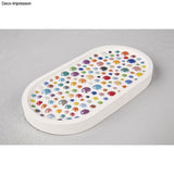 Eine ovale Platte mit bunten Glaskugeln, kreativ arrangiert, präsentiert von Easy-Sticks.