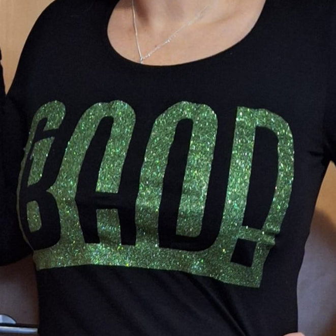 Frau trägt ein schwarzes Longsleeve mit glitzerndem grünen Schriftzug 'BAD!' - Eine modische Umsetzung der Good Bad Plotterdatei von easy-sticks.