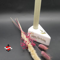 Stylische Geburtstagskerze in Form eines Kuchenstandes, designt mit "Happy Birthday" Schriftzug von easy-sticks, perfekt für deine kreative Feier.