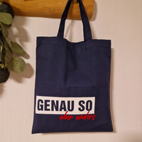 Tote Bag in Dunkelblau mit dem Slogan 'GENAU SO aber anders' von easy-sticks, ideal für den Einkauf oder als stylisches Accessoire.