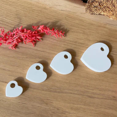 Verschiedene Silikonherzen zum Aufhängen von Easy-Sticks, ansprechend auf einem Holztisch arrangiert für kreative Bastelprojekte.