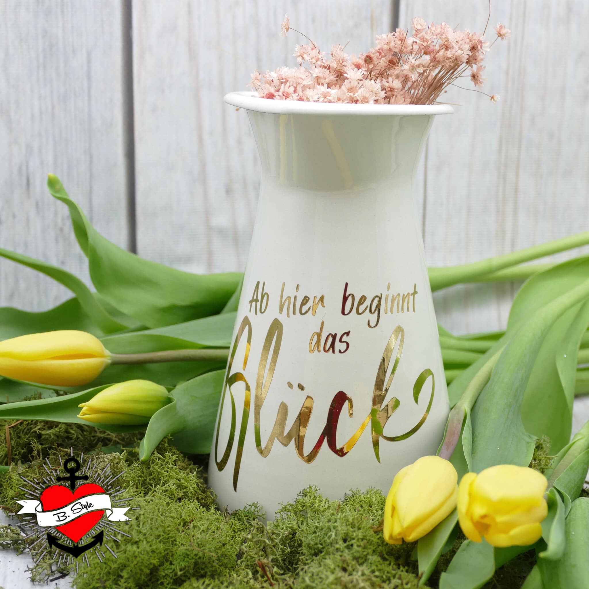 Elegante Vase mit der inschriftlichen Botschaft 'Ab hier beginnt das Glück', gestaltet von easy-sticks. Die goldene Schrift auf dem weißen Keramikgefäß macht es zu einem stilvollen Dekorationsstück.