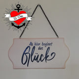 Hängendes Holzschild mit der Aufschrift 'Ab hier beginnt das Glück', designt von easy-sticks. Die Kombination aus rustikalem Holz und kreativer Schrift verleiht dem Schild einen besonderen Charme.