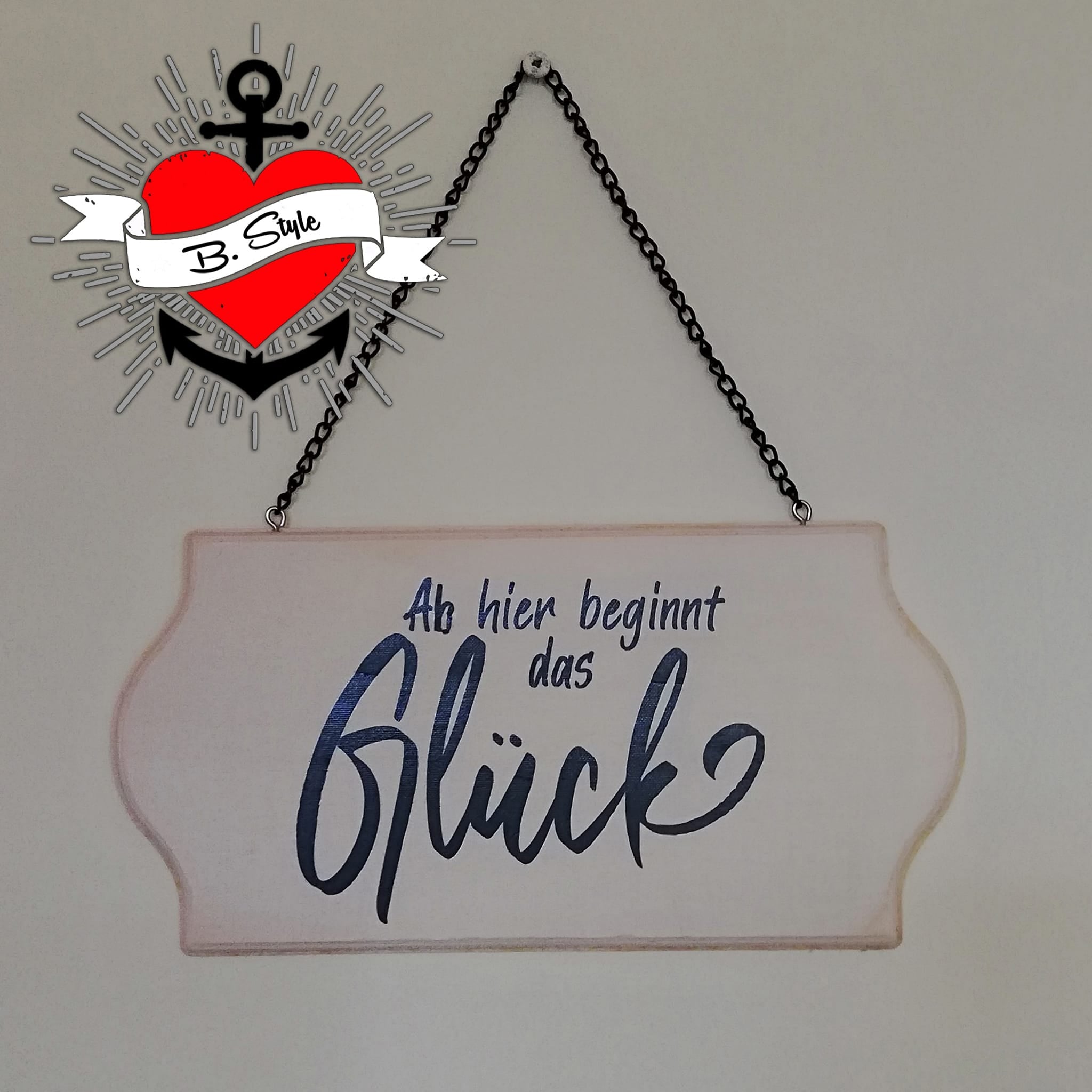 Hängendes Holzschild mit der Aufschrift 'Ab hier beginnt das Glück', designt von easy-sticks. Die Kombination aus rustikalem Holz und kreativer Schrift verleiht dem Schild einen besonderen Charme.