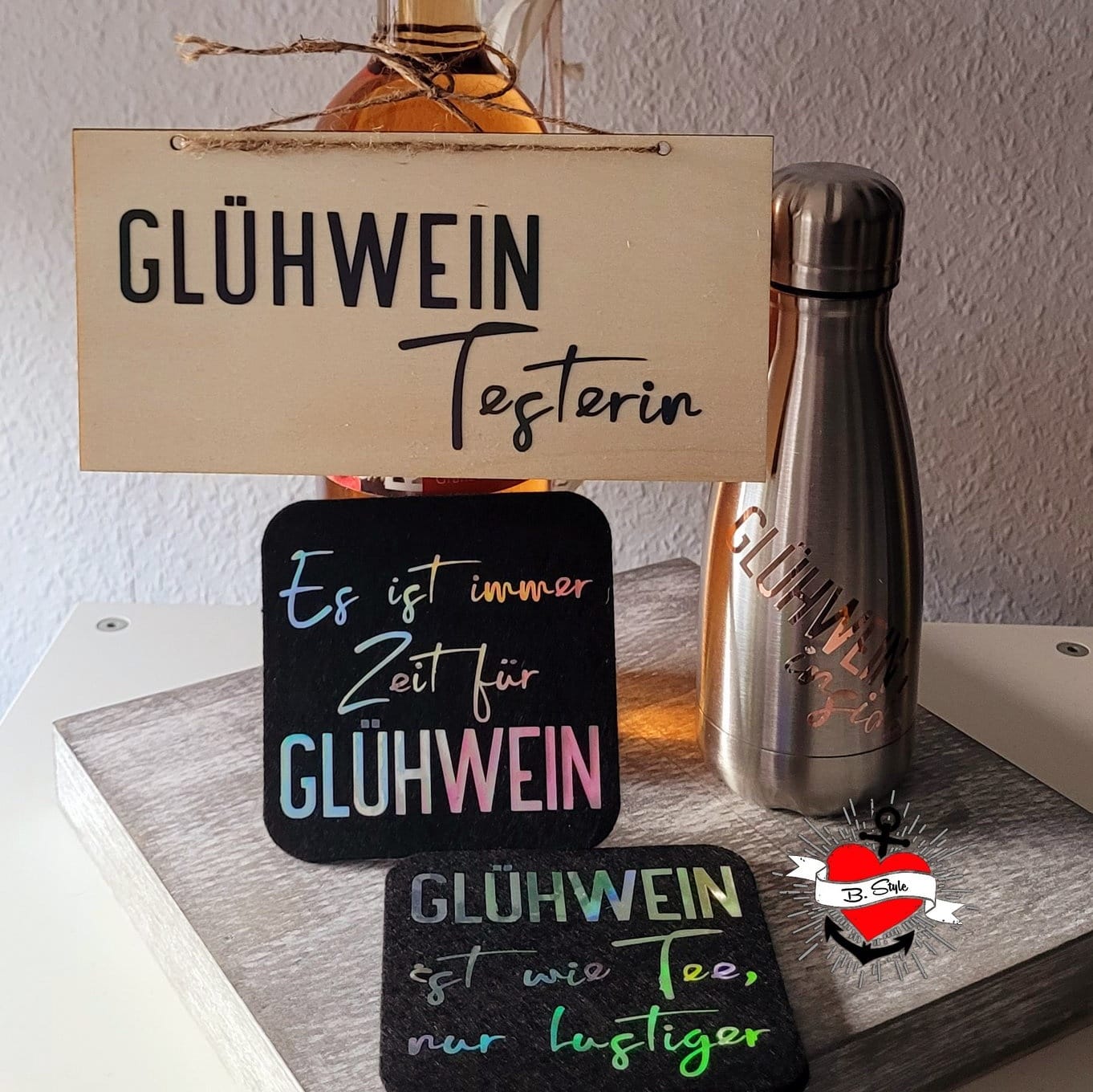 Ein rustikales Präsentationssetup für Glühwein mit einer Holztafel und farbenfrohen Untersetzern. Designs inspiriert von easy-sticks und Teil der Glühwein Plottersprüche Plotterdatei.
