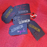 Vielfältige Etiketten mit Glühwein Sprüchen, kreatives Design aus der Glühwein Plottersprüche Plotterdatei von easy-sticks, ideal für persönliche Bastelprojekte.