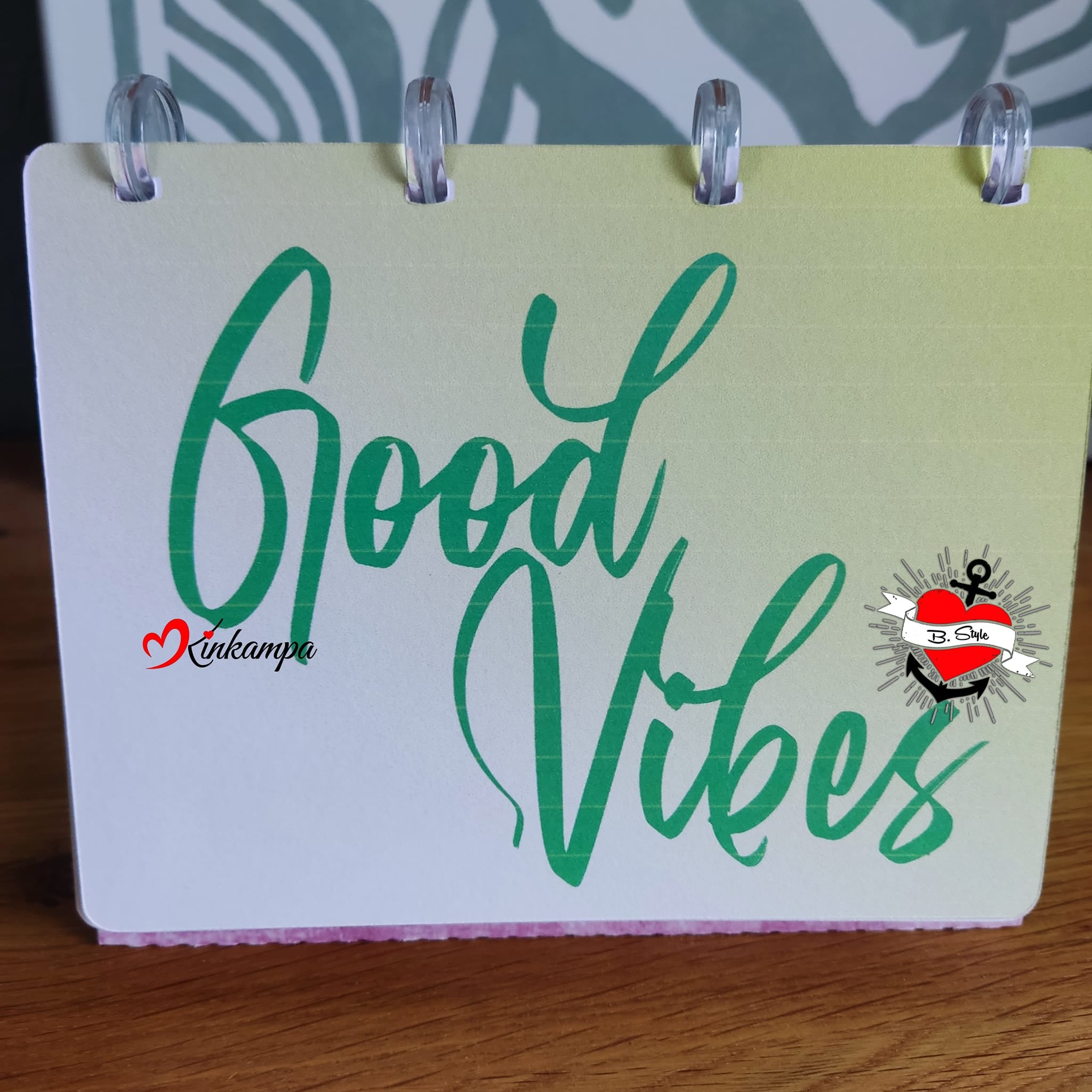 Kreative Anwendung der "Good Vibes" Plotterdatei von easy-sticks, zeigt den eleganten Schriftzug auf einem bunten Notizblock, ideal für personalisierte Designs.