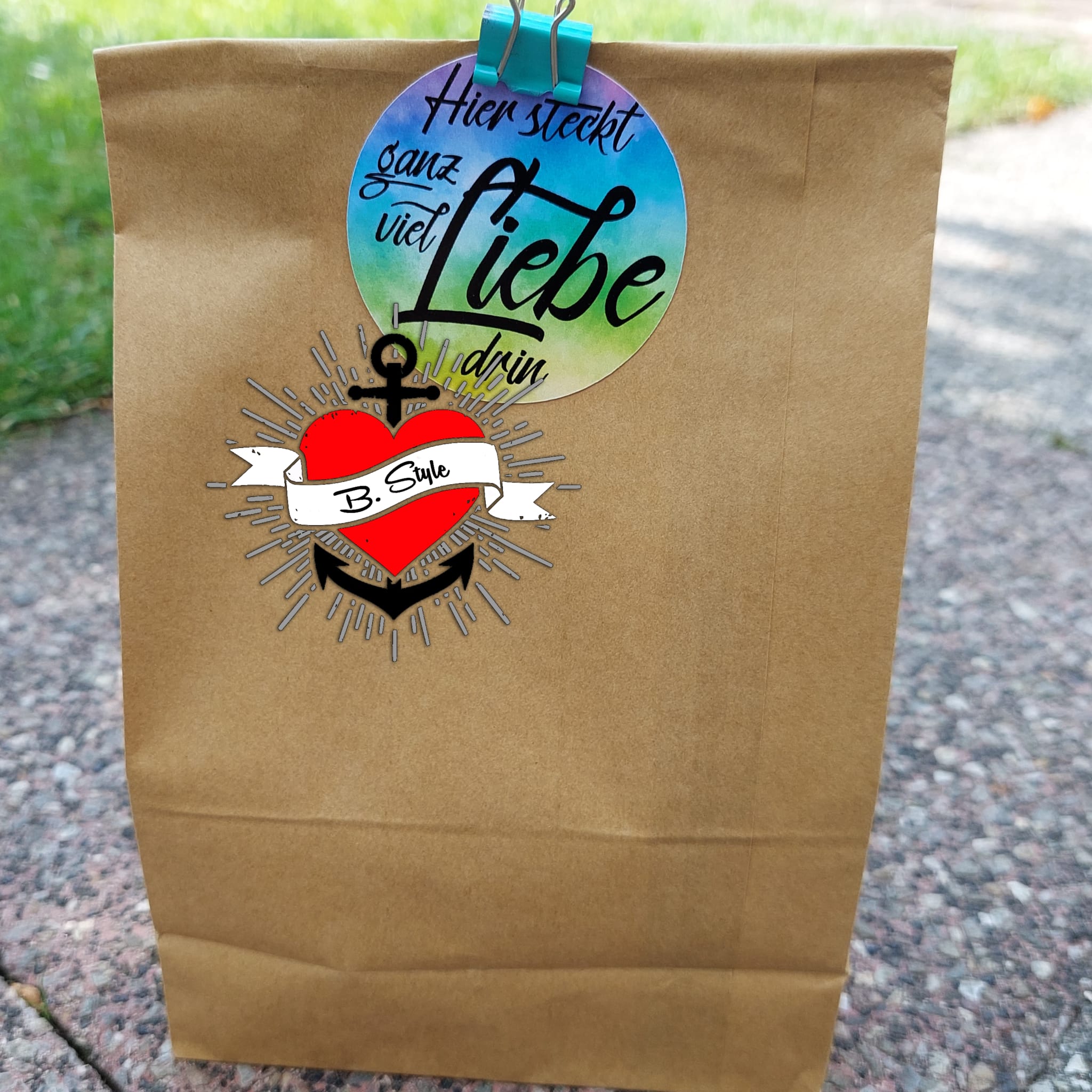 Ein brauner Geschenktüte mit einem kreativen Aufkleber aus der Grüße Plotterdatei von easy-sticks.