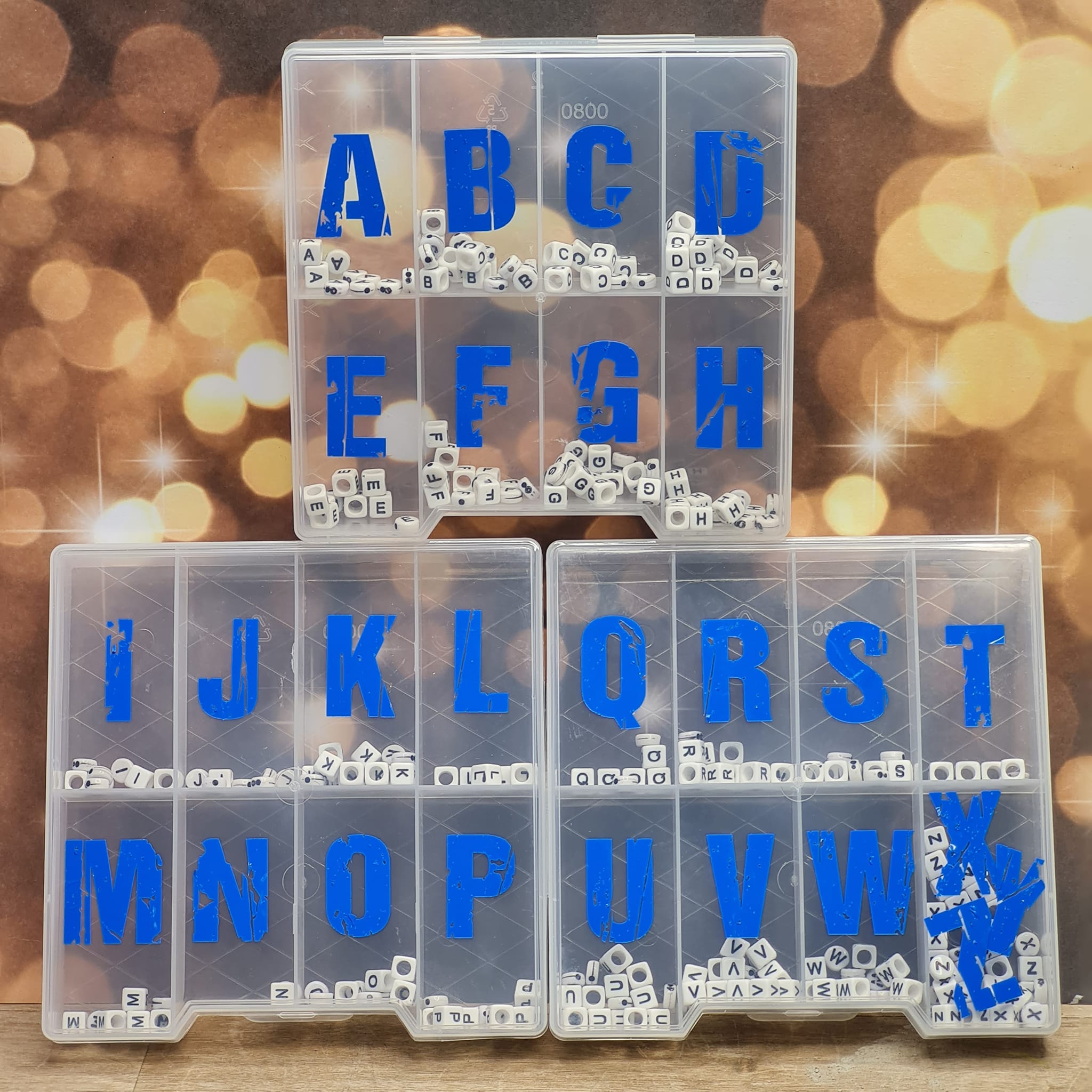 Grunge Schrift Plotterdatei von easy-sticks. Bild von Kunststoffbehältern mit alphabetischen Buchstaben in blauer Farbe auf einem glänzenden Hintergrund.