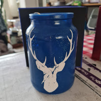 Kunstvolle Grunge Hirsch Plotterdatei von easy-sticks auf einem blauen Glasbehälter, einzigartiges Hirschdesign in Weiß, geeignet für kreative DIY-Ideen.
