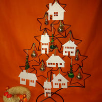 Ein dekorativer Weihnachtsbaum aus Draht mit weißen Häusersilhouetten von easy-sticks, die die "Häuser" Plotterdatei darstellen, umgeben von buntem Weihnachtsschmuck.