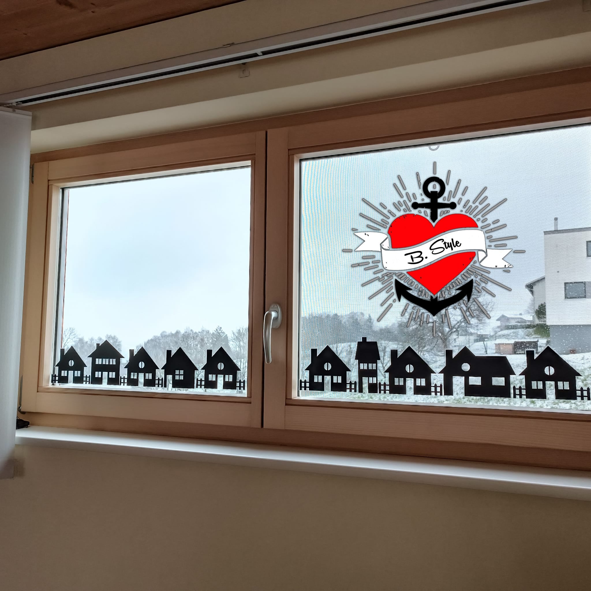 Fensterdekoration mit stilisierten schwarzen Häusersilhouetten von easy-sticks, die die "Häuser" Plotterdatei repräsentieren und einen festlichen, kreativen Touch verleihen.