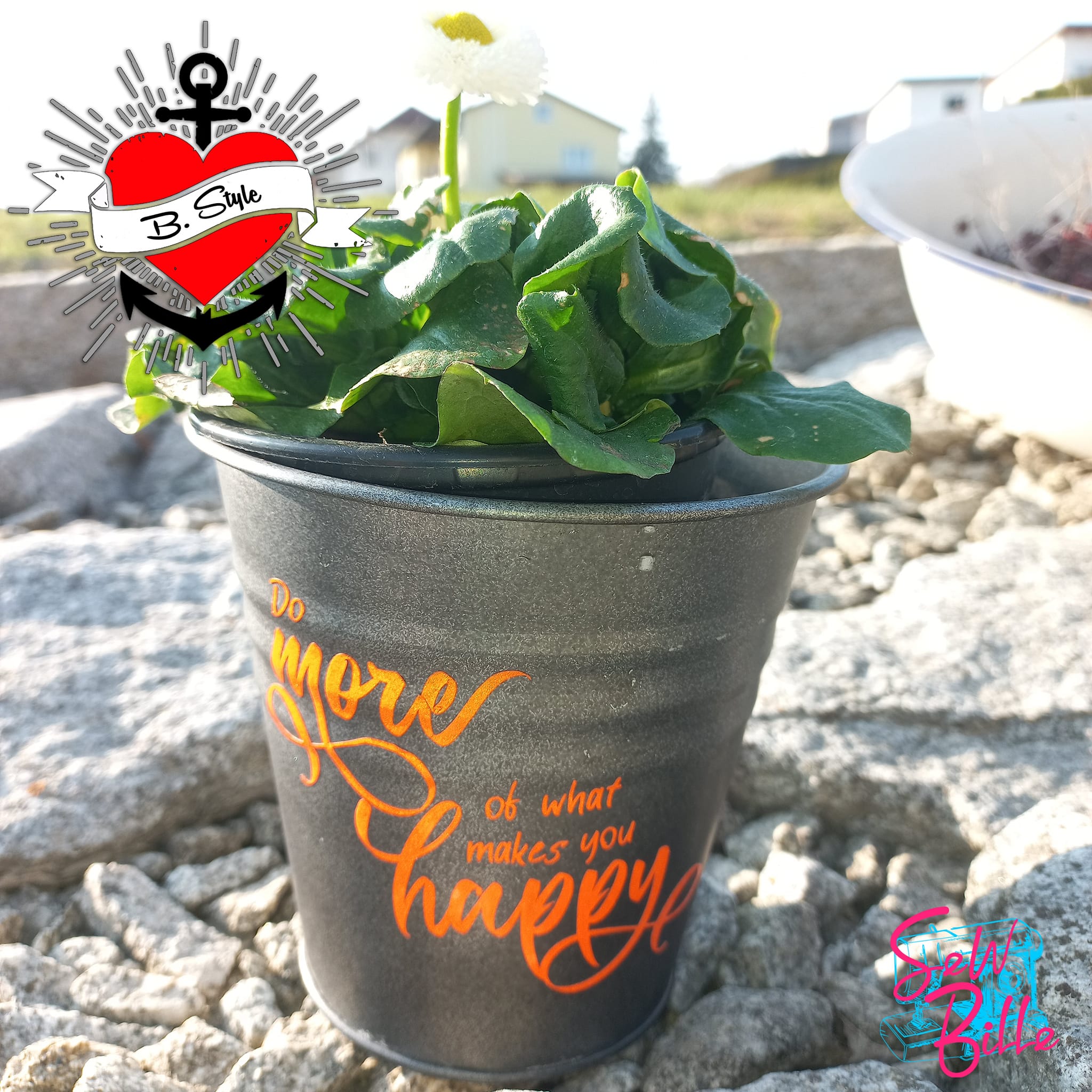 Kübel mit schöner Pflanze, verziert mit dem Spruch 'Do more of what makes you happy' in leuchtendem Orange, aus der Plotterdatei von easy-sticks, ideal für gärtnerische DIY-Projekte.