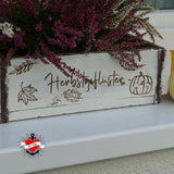 Stilvolles Blütenarrangement in einer Holzbox mit der Aufschrift 'Herbstgeflüster', perfekt für die Herbstdekoration. Herbstdiy Sprüche für den Plotter und in PDF zum Ausdrucken auf Wasserschiebefolie von easy-sticks.