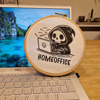 Kreatives Homeoffice Design von easy-sticks, gezeichnet als ein Skelett, das an einem Laptop arbeitet, umgeben von natürlicher Schönheit.