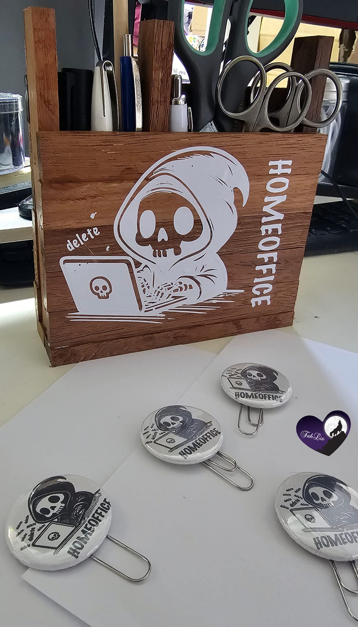 Holzstifthalter mit Homeoffice Motiv von easy-sticks, zeigt ein Skelett hinter einem Laptop, dazu verschiedene Büroartikel.
