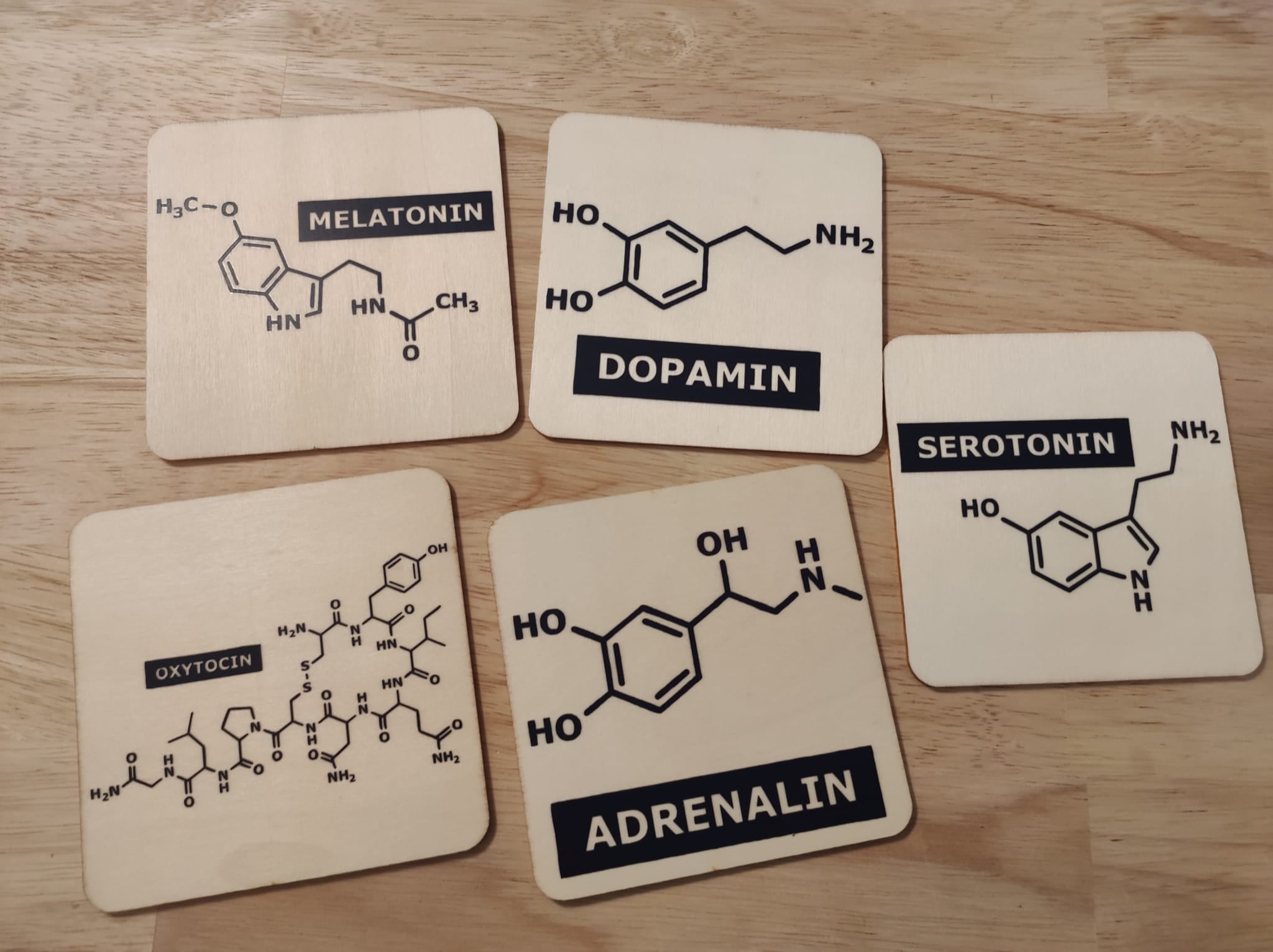 Holzuntersetzer mit chemischen Formeln für Hormone, präsentiert in einem ansprechenden Design, erhältlich in der Plotter Datei 'Hormone Zeichen' von easy-sticks.