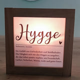 Schöne Lichtbox mit dem Schriftzug "Hygge" und einer Beschreibung der Gemütlichkeit, ideal für die kreative Gestaltung mit dem PDF Download von easy-sticks fürLaternen und Lichtboxen.