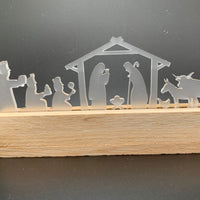 Stilvolle Krippe satiniert von Easy-Sticks, zeigt die Geburt Jesus mit detaillierten Figuren und Holzsockel. Perfekt für festliche Dekoration.