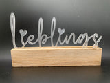 Stylishes Acrylschild "Lieblings" von Easy-Sticks, elegant auf einem Holzständer präsentiert, ideal für individuelle Anlässe und Dekorationen.