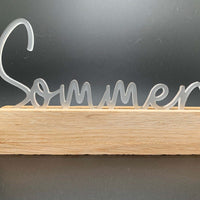 Eleganter Easy-Sticks Acryl Aufsteller mit dem Schriftzug 'Sommer' auf einem Holzsockel, perfekt als Dekoration für die Sommerzeit.