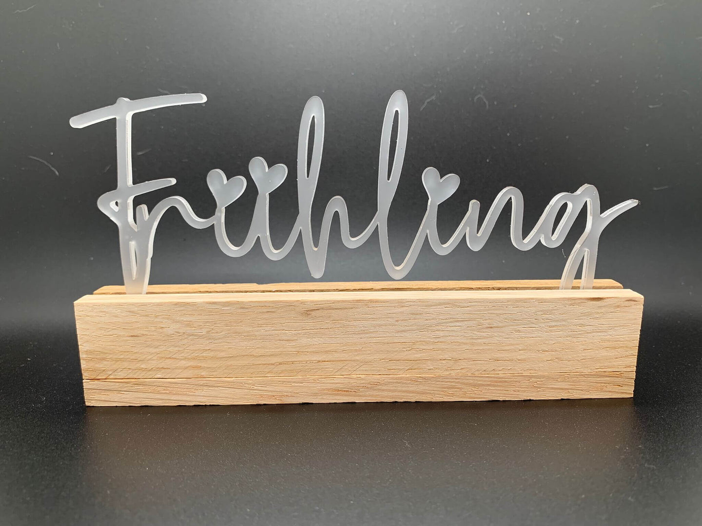 Eleganter Acryl Aufsteller "Frühling" von Easy-Sticks, der in einem Holzständer präsentiert wird und fröhliche Frühlingsakzente setzt.