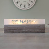 Eleganter Acryl-Easy-Stick 'BE HAPPY' von Easy-Sticks, leuchtet warm auf einem Tisch und schafft eine einladende Atmosphäre.